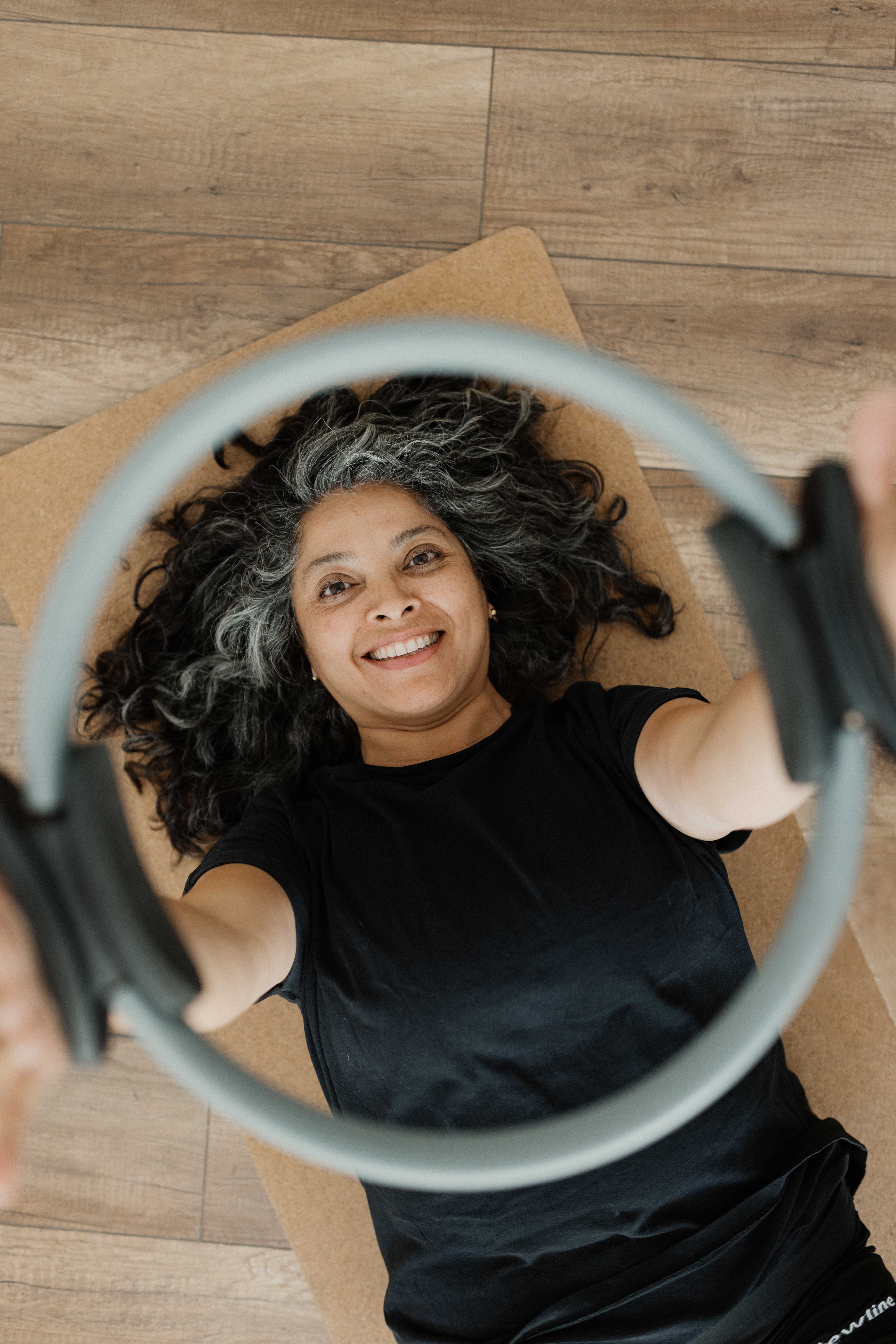 Pilates Training – lächelnde Frau beim Trainieren in Gymnistikraum