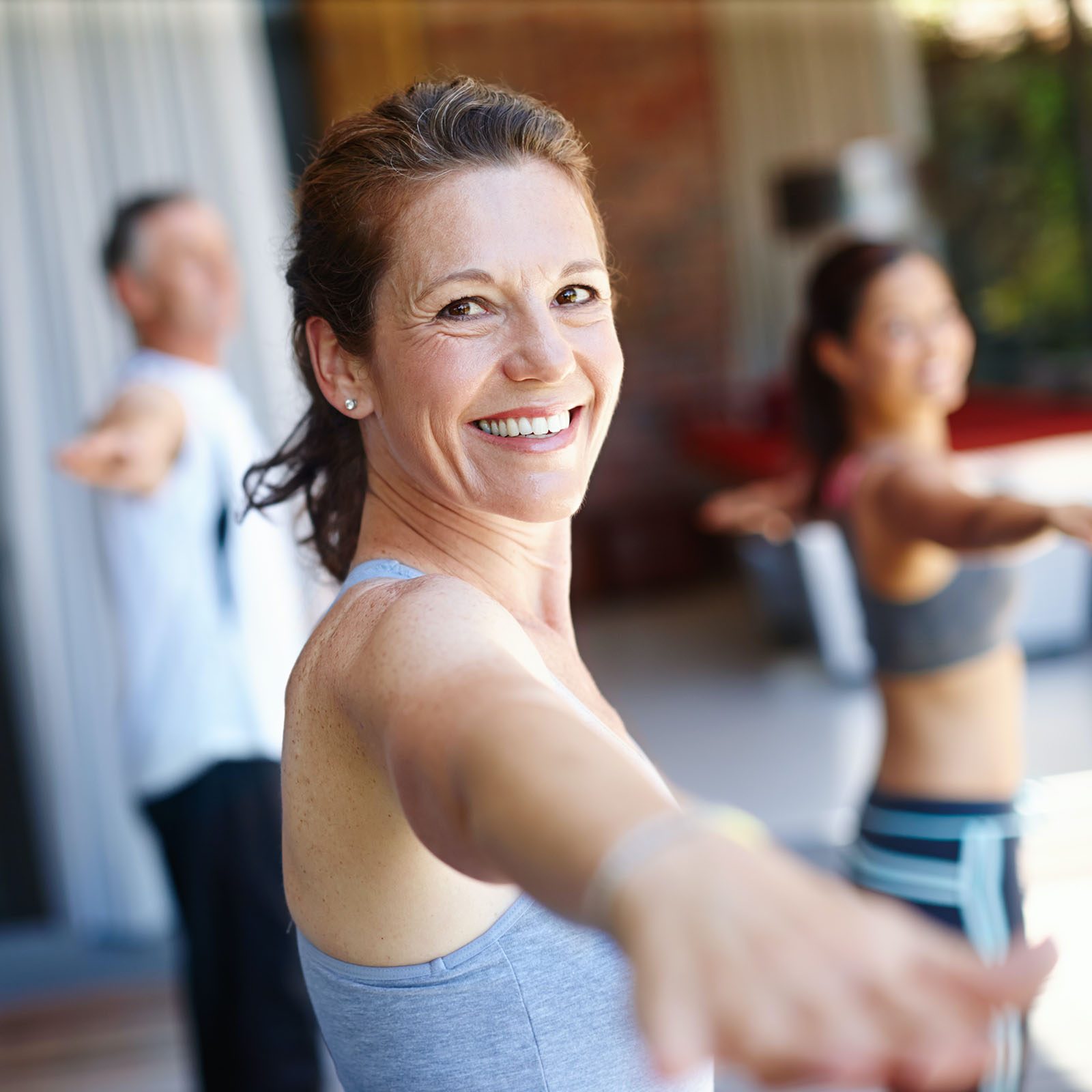 Pilates Training – lächelnde Frau beim Trainieren in Gymnistikraum